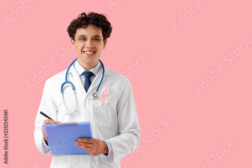 Breast cancer awareness and medical support, male doctor with pink ribbon and...