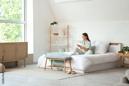 Slow living and morning routine, woman in pajamas using smartphone on bed in ...