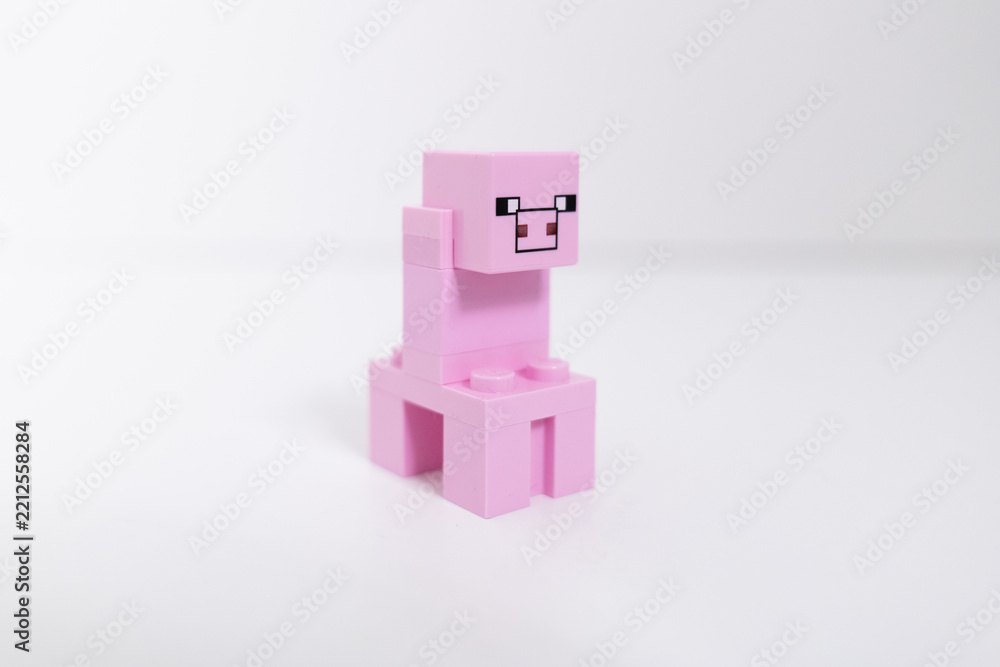 Naklejka premium Lego Minecraft pink pig mini-figure shot isolated on a white backgound. Bradford, UK Oct 2 2026