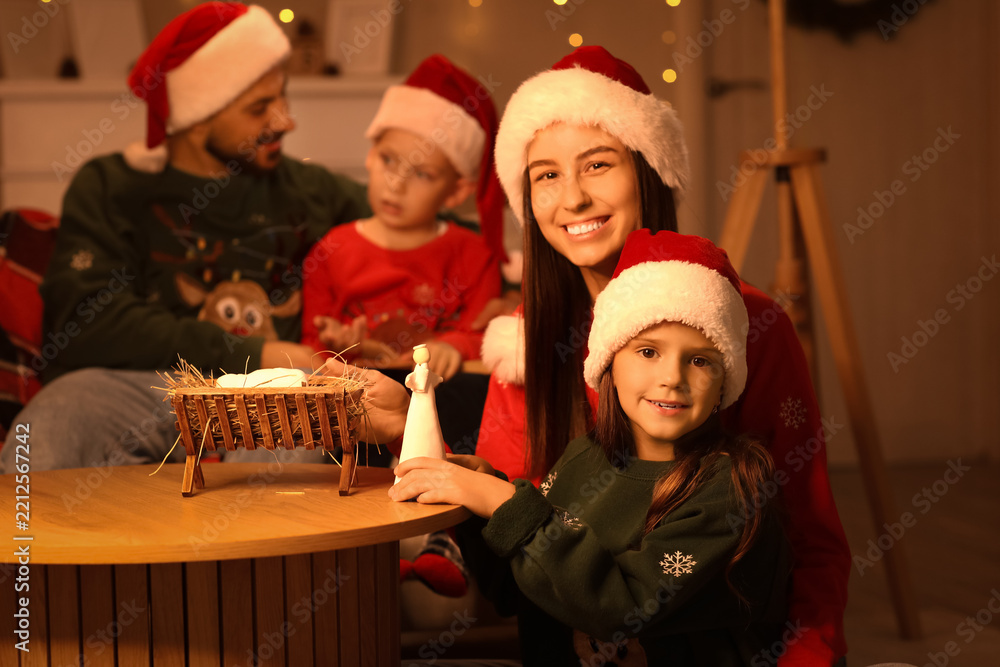 Obraz premium Happy mother with her little daughter recreating Christmas story at home in evening
