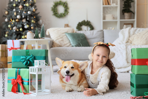 Cute happy girl in deer horns with Corgi dog, Christmas gift boxes and lanter...