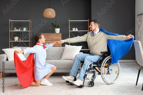 Disability inclusion and family bonding, father in wheelchair and daughter pl...