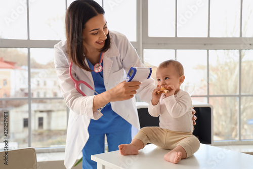 Pediatric healthcare and child wellness, female doctor using infrared thermom...