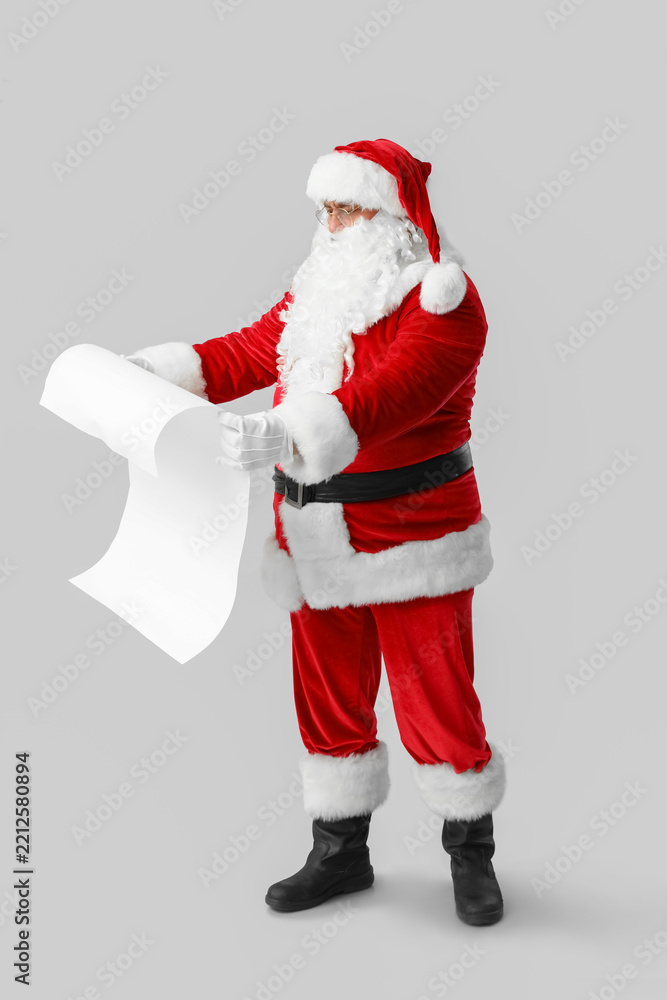 Obraz premium Santa Claus with reading letter on grey background