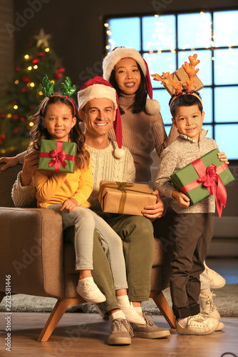 Happy family with presents at home on Christmas eve