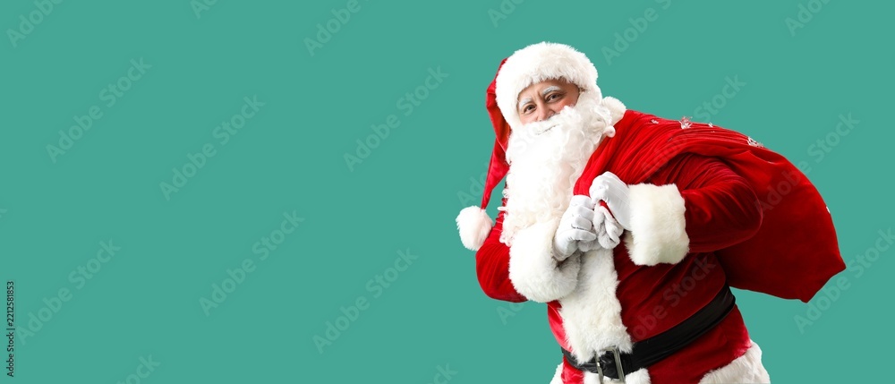 Obraz premium Santa Claus with bag full of Christmas gifts on green background with space for text