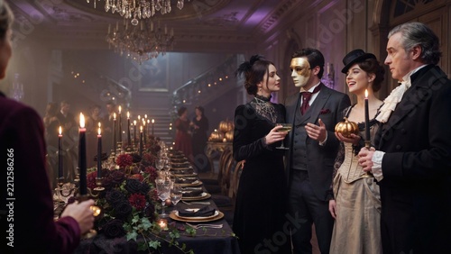 Victorian Halloween masquerade ball. Guests in historical costumes and masks