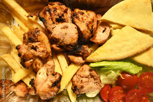 Chicken kebab with grilled vegetables, French fries and pita bread