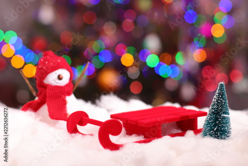 Red Santa sled on white snow and Christmas lights background