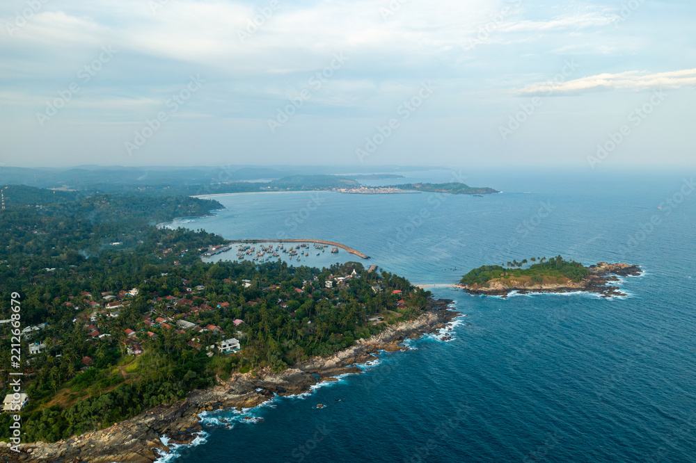 Fototapeta premium Aerial view of Nilwella fishing harbor and Blue Beach Island in Sri Lanka.
