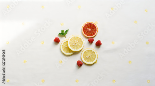 Fresh lemon slices with red blood orange, raspberries and mint leaves