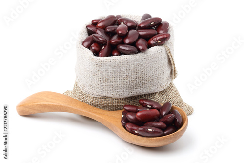 Red beans in a burlap sack and in a wooden spoon. isolated on white background.