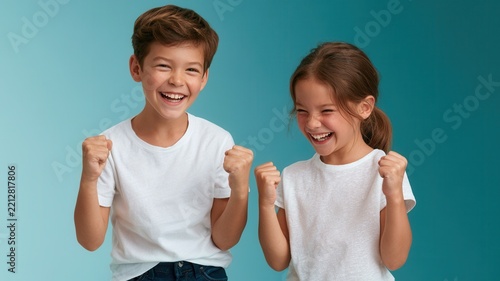 Happy children celebrating success and achievement two kids smiling with clenched fists excited and winning feeling