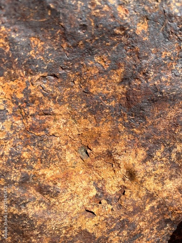 Close-up of weathered brown and rusty rock texture with rough uneven surface