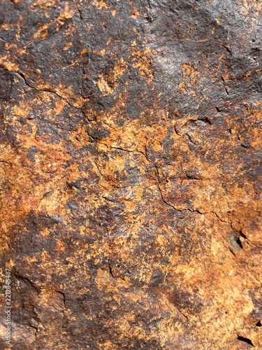 Close-up of weathered brown and rusty rock texture with rough uneven surface
