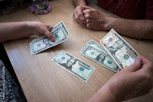A retired couple divides up US dollars for living expenses.
