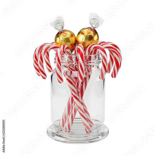 Christmas candy canes and gold chocolate balls in a glass jar isolated