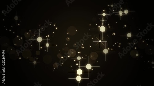Golden light particles glowing and shimmering with elegant bokeh effect on dark background.