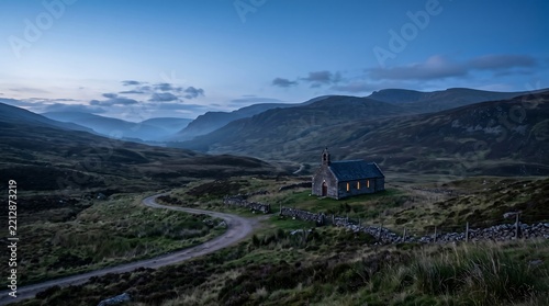 Old stone cottage in remote Scottish Highlands valley during blue hour with dramatic moody atmospheric mountain landscape