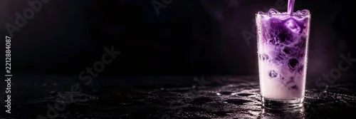 Panel kuchenny z motywem Iced ube latte with purple yam swirls and milk pouring into glass with ice. Cold taro beverage on wet dark surface with moody background. Horizontal banner with copy space for drink advertising