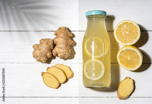 Healthy ginger lemonade with fresh ingredients on a bright white wooden surface