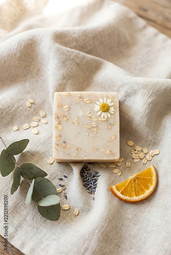 Natural handmade oatmeal soap bar with flower and orange slice on cloth