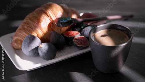 cup of espresso and a croissant with juicy figs, real-time footage and a breakfast idea, close-up of strong coffee