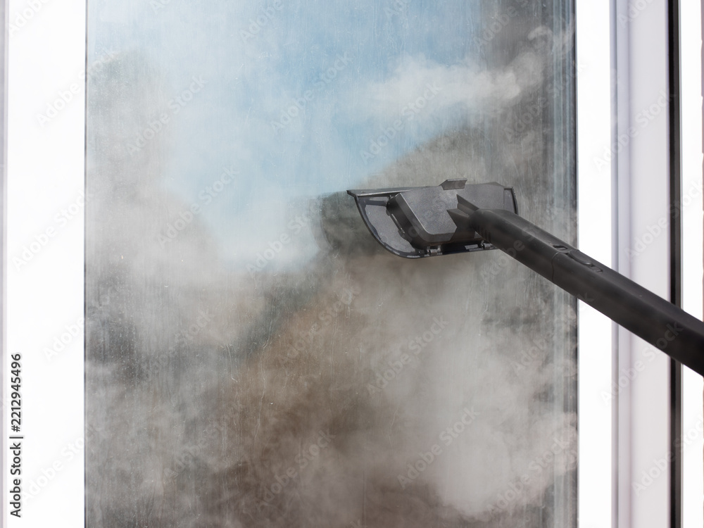 Fototapeta premium Window cleaning tool removing moisture from fogged glass in close up view