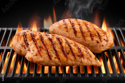 Chicken fillet on the barbecue grill with fire and smoke
