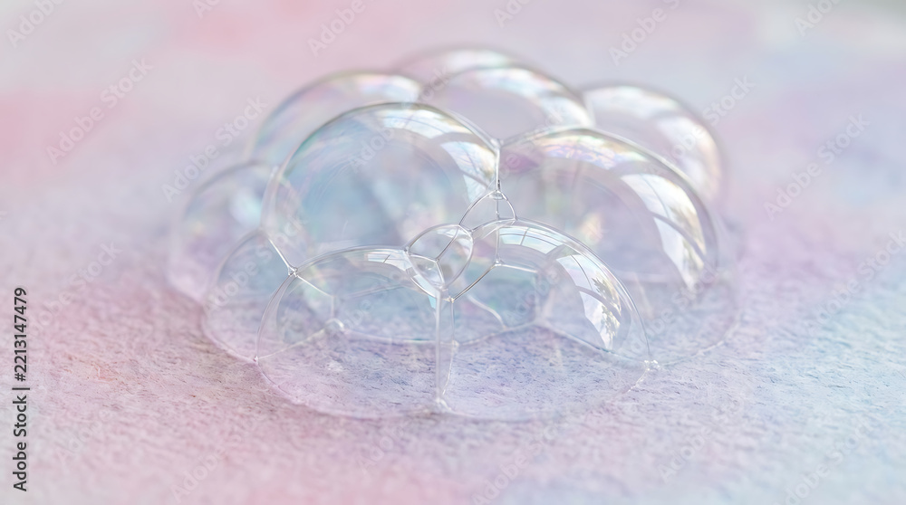 Fototapeta premium A close-up shot of shimmering soap bubbles resting delicately on a soft, pastel-colored watercolor background