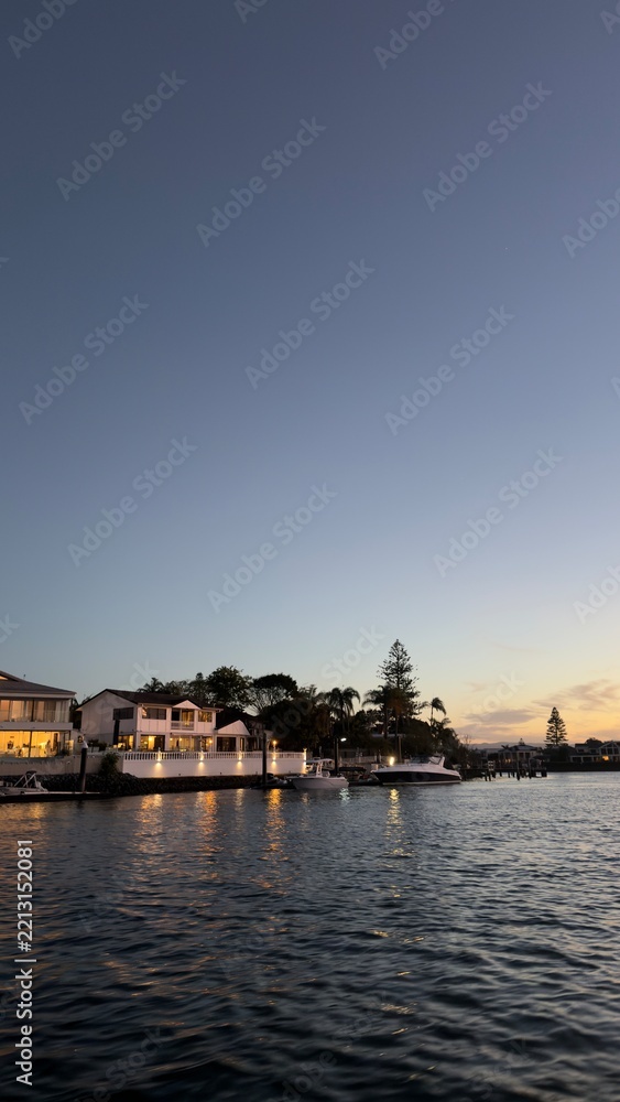 Fototapeta premium Waterfront Luxury Houses and Boats Along Canal at Sunset