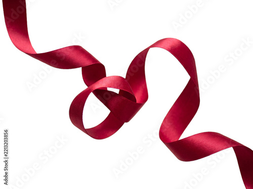 A flowing red silk ribbon isolated on a black background for holiday gift wrapping and celebration design
