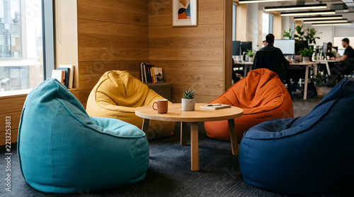 Vibrant beanbag seating around table in modern office lounge.