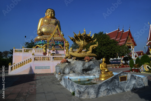 A large brilliantly gold-colored statue of Phra Maha Kaccayana Thera, holding a holy water vessel representing the 76 provinces standing 20 meters at Wat Lang San Prasit.