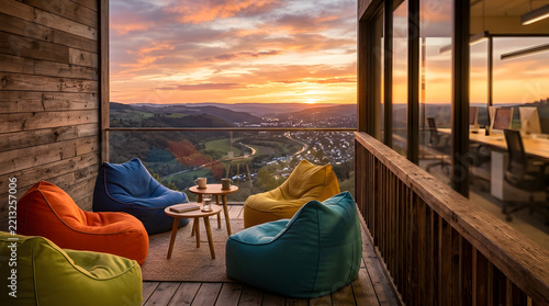 Wooden balcony with bean bag chairs overlooking scenic valley.
