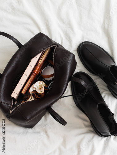 Women’s brown leather bag and leather boots are stylish, fashionable accessories