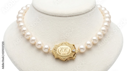 Elegant pearl necklace with ornate gold clasp on display stand