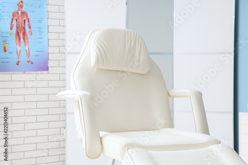 Medical aesthetics and skincare clinic, empty treatment chair in a modern doc...