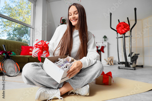 Fitness gift and healthy lifestyle, happy woman opening a box with new sneake...