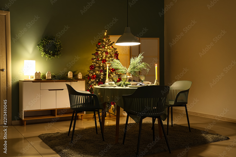 Fototapeta premium Christmas dinner celebration, festive dining room interior with decorated tree and table setting for holiday gathering in a cozy home atmosphere