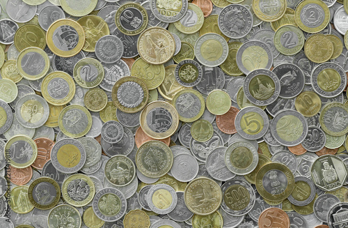 Macro shot showing many coins from worldwide locations, heaped. Assorted denominations