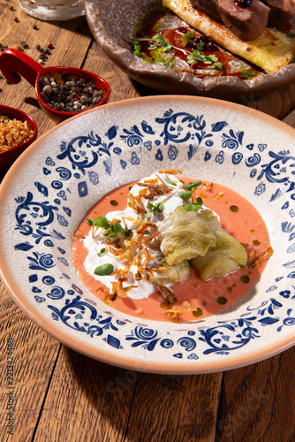 Cabbage rolls with sour cream and fried onions in ceramic bowl