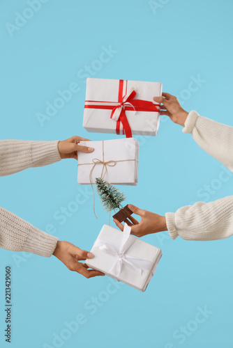 Female hands with Christmas gifts, letters and decorative fir tree on color background