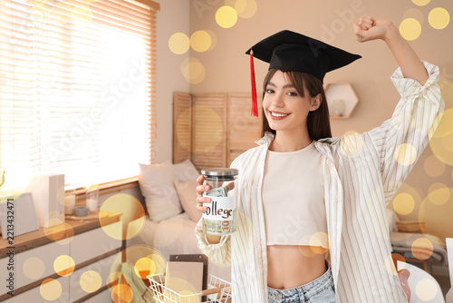 Student debt and college savings, happy graduate holding a glass jar with mon...