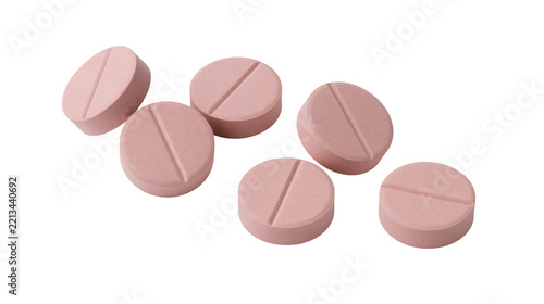 Isolated close-up of six round pink medicine pills with a score line for easy dosage