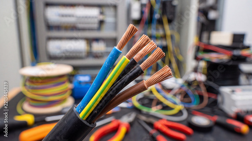 Electrical cables with various colors and tools in a workspace during a technical project
