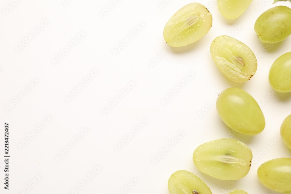 Fototapeta premium Fresh ripe grapes on white background, flat lay. Space for text