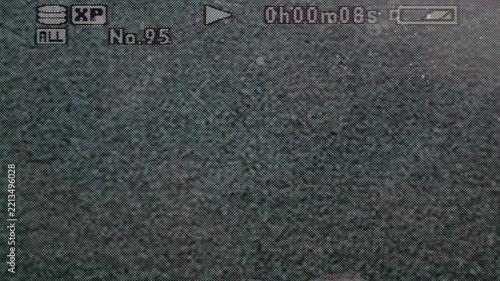 Close-up of a vintage digital camcorder playback display featuring recording information, timecode, battery indicator and analog-style visual noise.