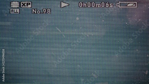 Light on old camcorder screen with pixel signal, playback overlay, fingerprints on display, video overlay via blend mode in 4k.
