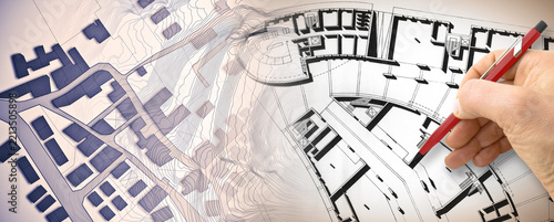 Planning a new city - Engineer-architect drawing with a pencil a sketch of a new modern imaginary town - concept image